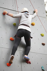 Girl exercises on indoor rock climber