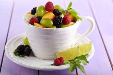 Fruit salad in cup on wooden table