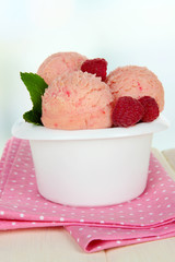 Tasty ice cream scoops in bowl, on table