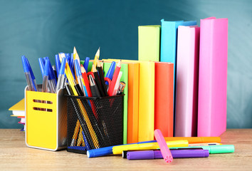Office supplies on table on school board background