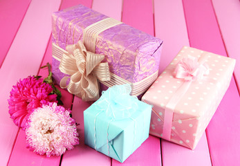 Gifts and flowers, on bright wooden background