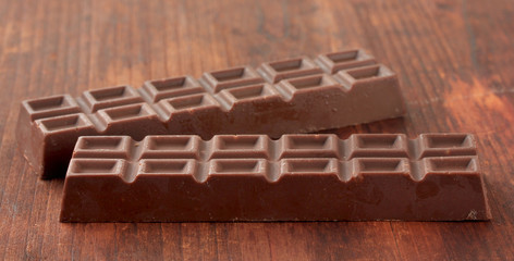Two delicious chocolate bars on wooden background