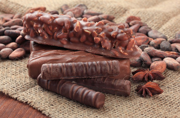 Delicious chocolate bars with cocoa beans close up