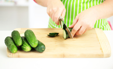 Happy smiling woman in kitchen preparing vegetable salad