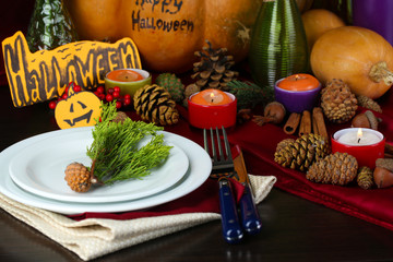 Table setting for Halloween with pumpkin and candles close-up