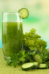 Glass of green vegetable juice and vegetables