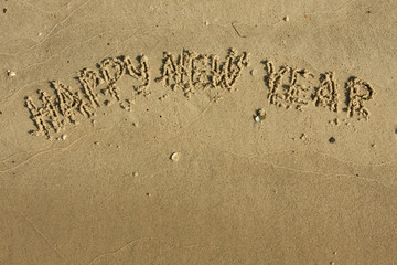 Inscription Happy new year on the sand