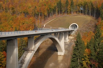 Rundbogenbrücke im Bau mit Tunneleingang im Herbst