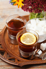 Set of cups with black tea on tray