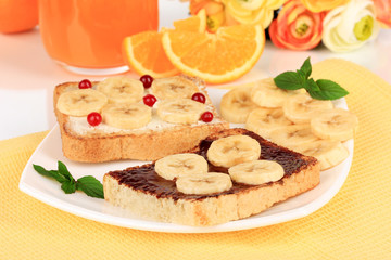 Delicious toast with bananas on plate close-up