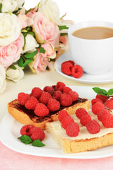 Delicious toast with raspberries on table on light background