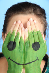 Portrait of girl hiding her face under smile mask isolated