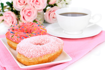 Sweet donuts with cup of tea on table close-up