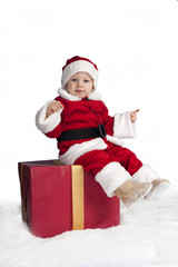 little santa claus seated on a christmas present i