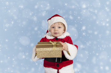 little toddler in xmas outfit giving a present