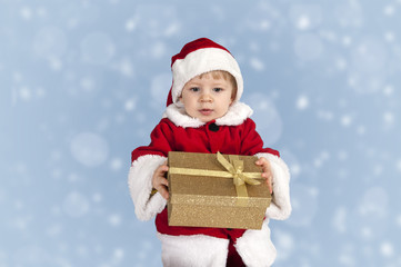 little toddler in xmas outfit giving a present