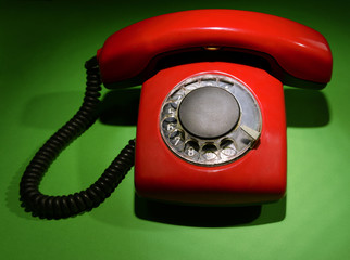 Red retro telephone on dark color background