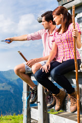 Alpen - Mann und Frau vor Almhütte in Bergen