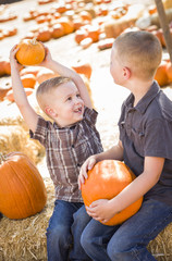 Fototapeta premium Two Brothers at a Pumpkin Patch Talking and Having Fun.