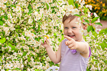 Little girl on a background of bush with flowers