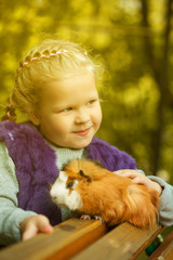Slyly smiling girl posing with guinea pig