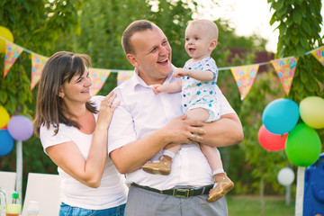 Happy family celebrating first birthday of baby