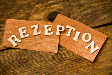 das Wort REZEPTION auf Holztafel