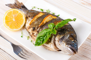 Dorado fish with lemon and spices on a wooden board - 57386769