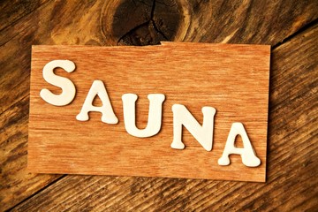 das Wort SAUNA auf Holztafel