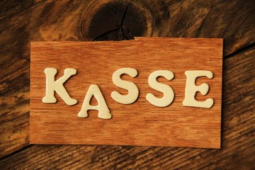 das Wort KASSE auf Holztafel