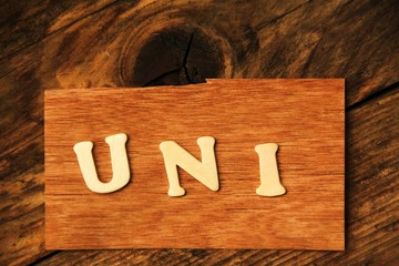 die Buchstaben UNI auf Holztafel