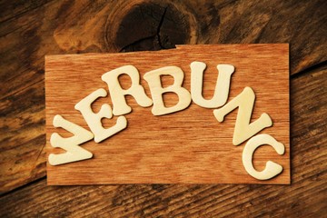 das Wort WERBUNG auf Holztafel
