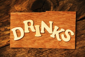 das Wort DRINKS auf Holztafel