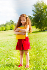 LIttle girl with books in park