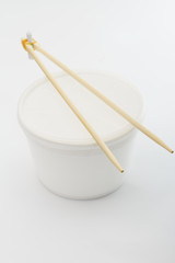 Plastic box with chopsticks on white background