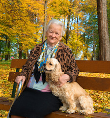 Old woman sitting on a bench with a dog