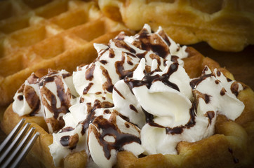freshly baked waffles with milk cream close up on the wood