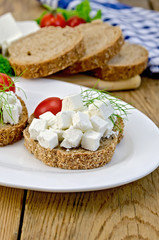Bread with feta cheese and tomatoes on the board