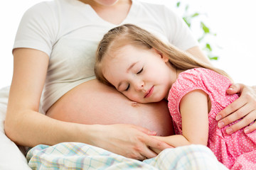 Obraz na płótnie Canvas kid girl listening pregnant mother's belly