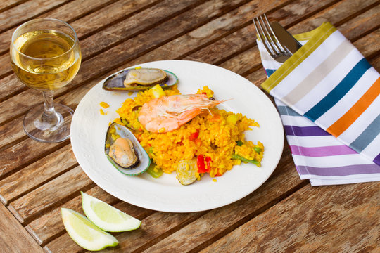Paella served in plate on wooden table