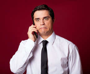 Man with mobilephone on red background