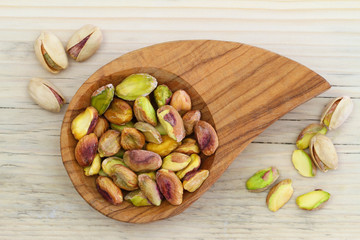 Pistachio nuts without shell in wooden bowl
