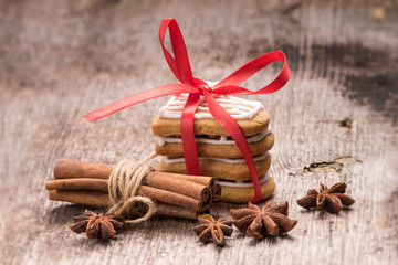 Gingerbread cookies with spices on wood background