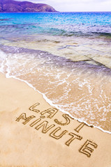 Last Minute written on sand, being washed away by waves