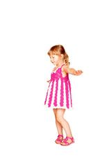 Happy little girl in knitted pink dress dancing.
