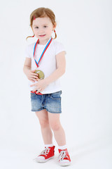 Little girl in shorts with medal on her chest stands