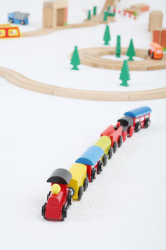 Toy train with cars and wooden toy railway with spruces