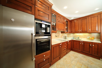 Light clean kitchen with wooden furniture, integrated oven