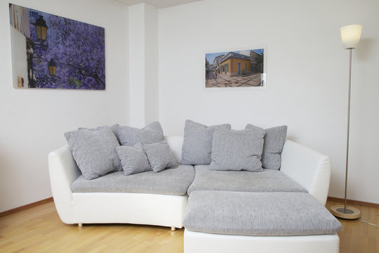 Modernes Sofa mit Hocker und vielen Kissen