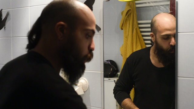 long beard and mustache man shaving in bathroom